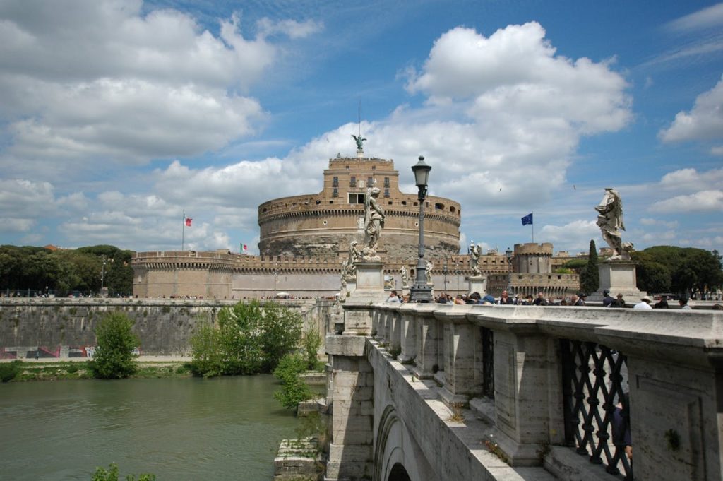 Historic Castel SantAngelo with statues on Ponte SantAngelo under a cloudy sky in Rome, Italy.